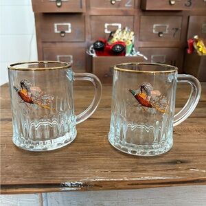 2 4” tall DEMA beer steins with pheasant design and gold rim